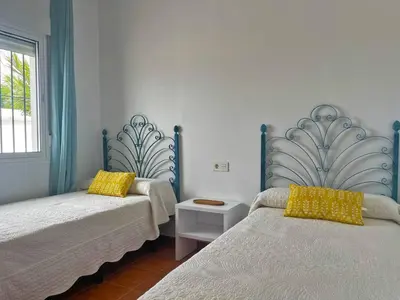 a bedroom with two beds with yellow pillows at Villa Nostos - Ole Solutions in Cádiz