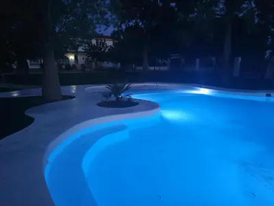 a swimming pool at night with blue lights at Hacienda Laguna Seca - Apart. Hibisco in Chiclana de la Frontera