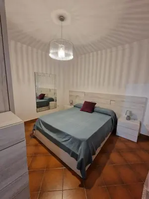 a bedroom with a bed and a chandelier at Chalet a 2 kilometros de la playa in Chiclana de la Frontera