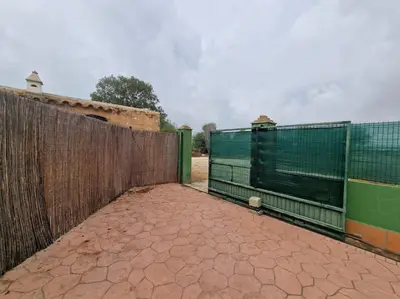 a wooden fence with a gate in front of a building at Chalet a 2 kilometros de la playa in Chiclana de la Frontera