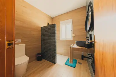 a bathroom with a sink and a toilet and a mirror at Chalet La Alberca in Chiclana de la Frontera