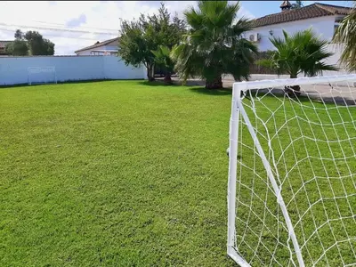 a soccer goal in a yard with palm trees at Chalet La Alberca in Chiclana de la Frontera