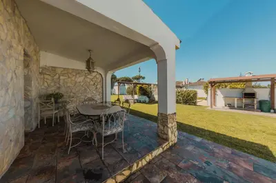 a patio with a table and chairs in a yard at Chalet La Alberca in Chiclana de la Frontera