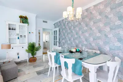 a dining room with a table and white chairs at Genteel Home Victoria in Cádiz
