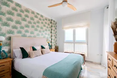 a bedroom with a large bed with a ceiling fan at Genteel Home Victoria in Cádiz