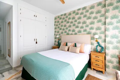 a bedroom with a white bed with a blue blanket at Genteel Home Victoria in Cádiz
