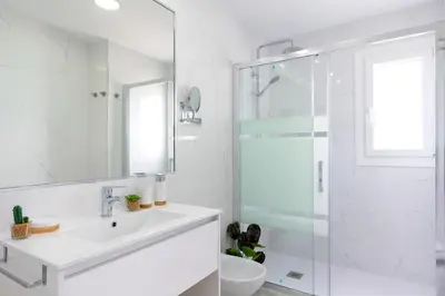 a white bathroom with a sink and a shower at Genteel Home Victoria in Cádiz