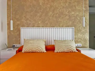 a bedroom with an orange bed with two pillows at Apartamento Klandestina - Ole Solutions in Cádiz