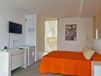 a bedroom with a bed with an orange blanket at Apartamento Klandestina - Ole Solutions in Cádiz