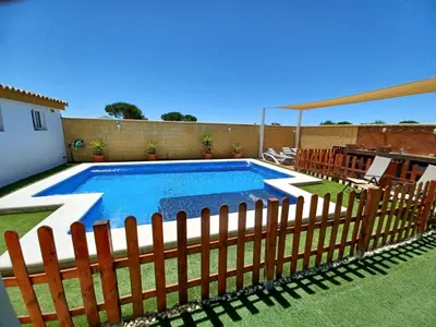 a swimming pool with a wooden fence around it at OHANA in Chiclana de la Frontera