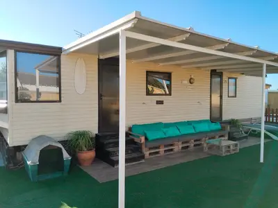 a house with awning and a couch on a deck at OHANA in Chiclana de la Frontera