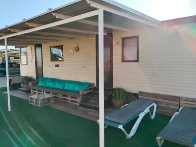 a covered patio with a couch and a table at OHANA in Chiclana de la Frontera