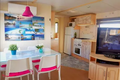 a kitchen with a table with chairs and a television at OHANA in Chiclana de la Frontera