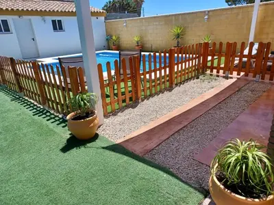 a wooden fence with potted plants in a yard at OHANA in Chiclana de la Frontera