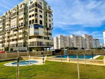 a large apartment building with a pool in front of it at GATU Villa Salada, junto la playa, parking, terraza, aire acc, piscina, wifi Sólo familias o grupos mayores de 21 años in El Puerto de Santa María