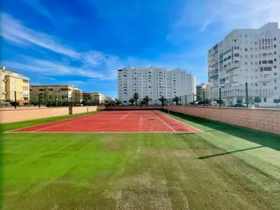 a tennis court in the middle of a city at GATU Villa Salada, junto la playa, parking, terraza, aire acc, piscina, wifi Sólo familias o grupos mayores de 21 años in El Puerto de Santa María
