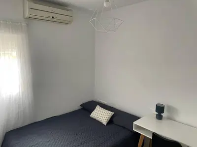 a bedroom with a bed and a desk and a window at Piso en el centro in San Fernando