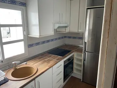 a kitchen with a sink and a refrigerator at Piso en el centro in San Fernando