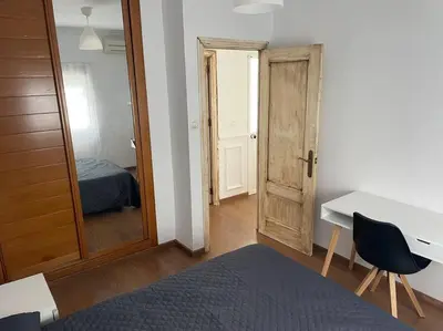 a room with a desk and a bed and a door at Piso en el centro in San Fernando