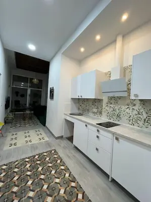 a kitchen with white cabinets and a tile floor at APARTAMENTO VEEDOR BUENAS COMPAÑIAS in Cádiz