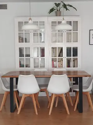 a dining room with a wooden table and two white chairs at Villa Ostrero in Chiclana de la Frontera
