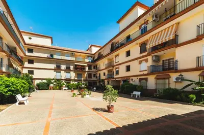 a courtyard of an apartment building with benches at Las Olas Chipiona in Chipiona