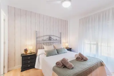 a white bedroom with a bed with towels on it at Las Olas Chipiona in Chipiona