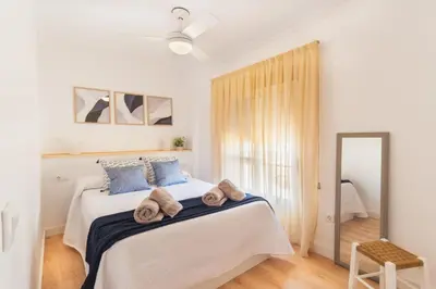a bedroom with a bed with towels on it at Las Olas Chipiona in Chipiona