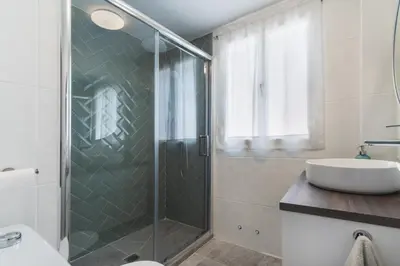 a bathroom with a glass shower and a sink at Las Olas Chipiona in Chipiona