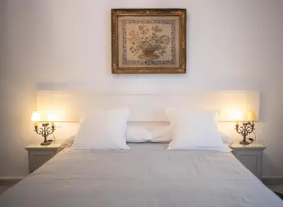 a bed with two lamps and a picture on the wall at GATU PREMIUM Apartamento Palacio Oneto con Jardín Privado 