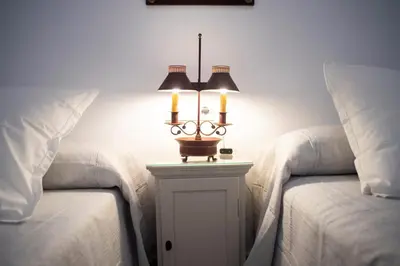 a bedroom with two beds and a lamp on a table at GATU PREMIUM Apartamento Palacio Oneto con Jardín Privado 