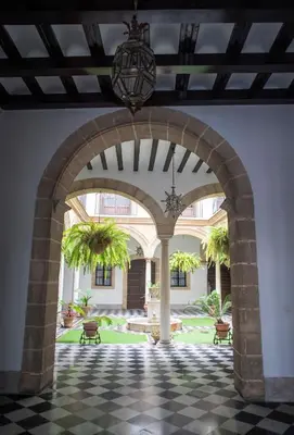 an archway leading to a courtyard with palm trees at GATU PREMIUM Apartamento Palacio Oneto con Jardín Privado 