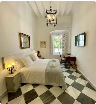 a bedroom with a bed and a checkered floor at GATU PREMIUM Apartamento Palacio Oneto con Jardín Privado 