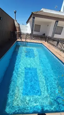 a pool with blue water in front of a house at Villa Bonita in Conil de la Frontera