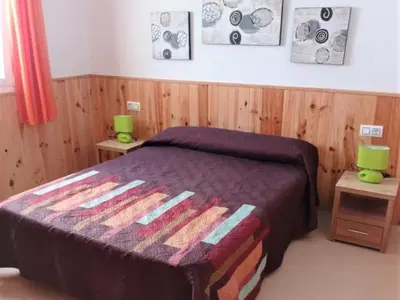 a bedroom with a bed and two tables with green lamps at Villa Bonita in Conil de la Frontera