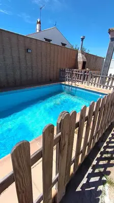 a swimming pool next to a wooden fence at Villa Bonita in Conil de la Frontera