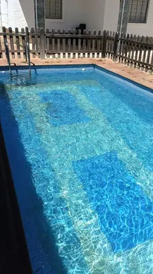 a swimming pool with blue water in a building at Villa Bonita in Conil de la Frontera