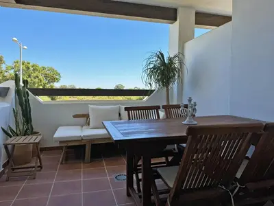 a porch with a table and chairs and a couch at Apartamento Dunas Candor - Ole Solutions in Rota