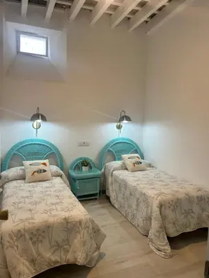 a bedroom with two beds and a window at Casa de Santa María in El Puerto de Santa María