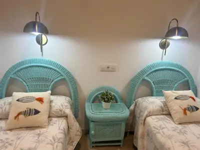 a room with two twin beds and a table at Casa de Santa María in El Puerto de Santa María