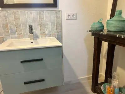 a bathroom with a sink and a wooden table at Casa de Santa María in El Puerto de Santa María