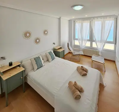 a bedroom with a large bed with two pairs of shoes on it at GATU PREMIUM Villa Turquesa Playa y Parking in Cádiz