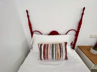 a bedroom with a white bed with a red headboard at GATU PREMIUM Villa Turquesa Playa y Parking in Cádiz