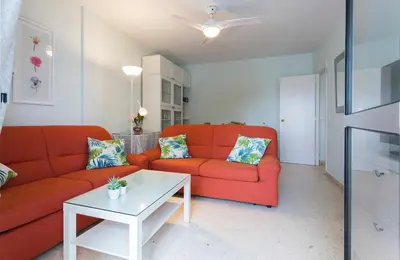 a living room with a red couch and a table at Azvalia - Valdelagrana Puerto Príncipe, Playa, piscina, parking in El Puerto de Santa María