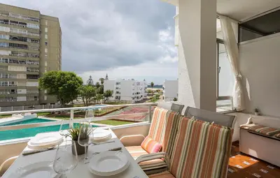 a balcony with a table and chairs and a pool at Azvalia - Valdelagrana Puerto Príncipe, Playa, piscina, parking in El Puerto de Santa María