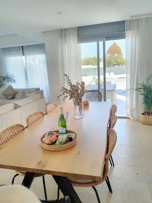 a dining room with a table and a couch at Exclusiva Villa Lujo con piscina privada by Chiclana Dreams in Chiclana de la Frontera