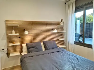 a bedroom with a large bed with a wooden headboard at Exclusiva Villa Lujo con piscina privada by Chiclana Dreams in Chiclana de la Frontera
