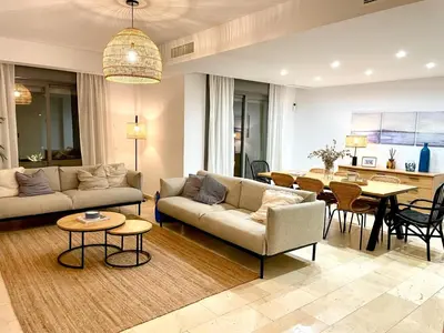 a living room with a couch and a dining room at Exclusiva Villa Lujo con piscina privada by Chiclana Dreams in Chiclana de la Frontera
