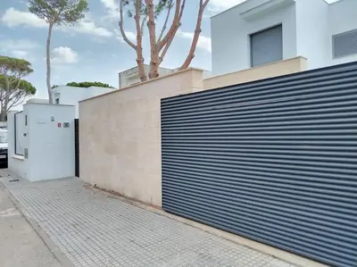 a fence with a gate in front of a building at Exclusiva Villa Lujo con piscina privada by Chiclana Dreams in Chiclana de la Frontera