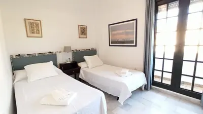 two beds in a room with a window at Villa Mar de Las Redes in El Puerto de Santa María